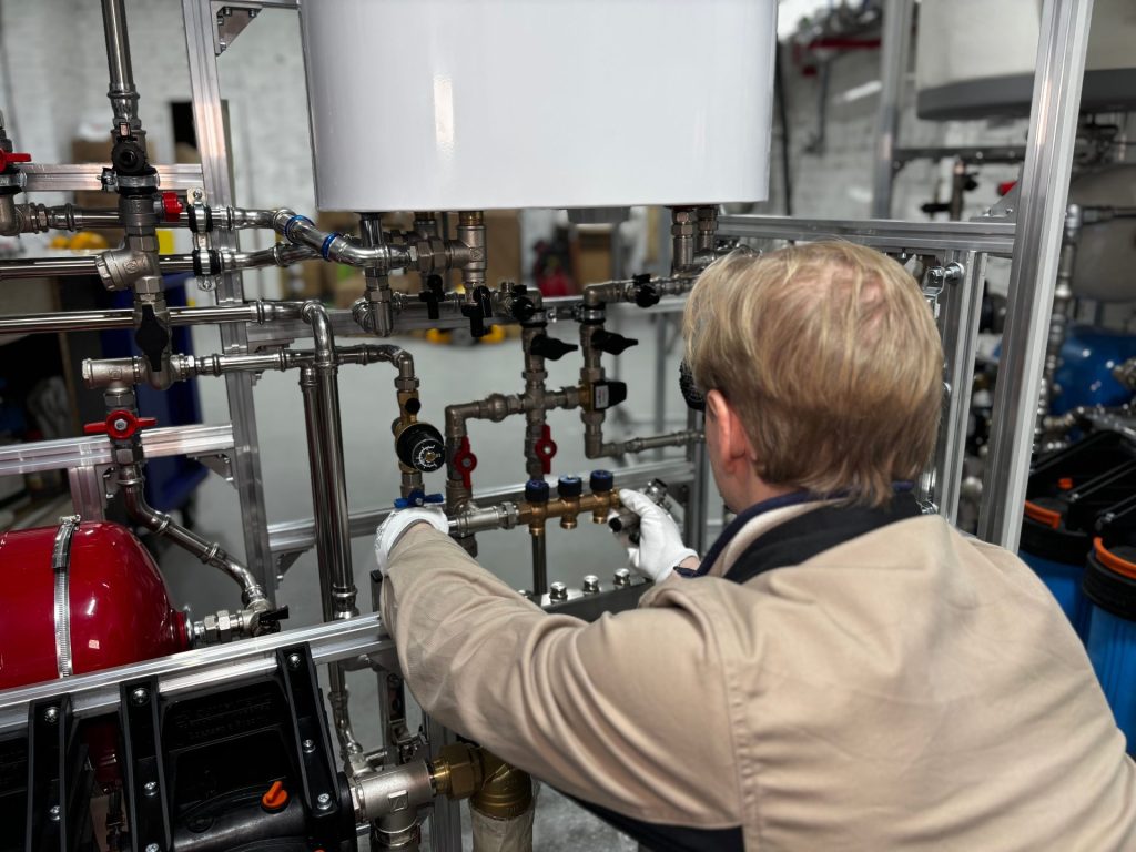 Engineer adjusting valves on an industrial pipework system