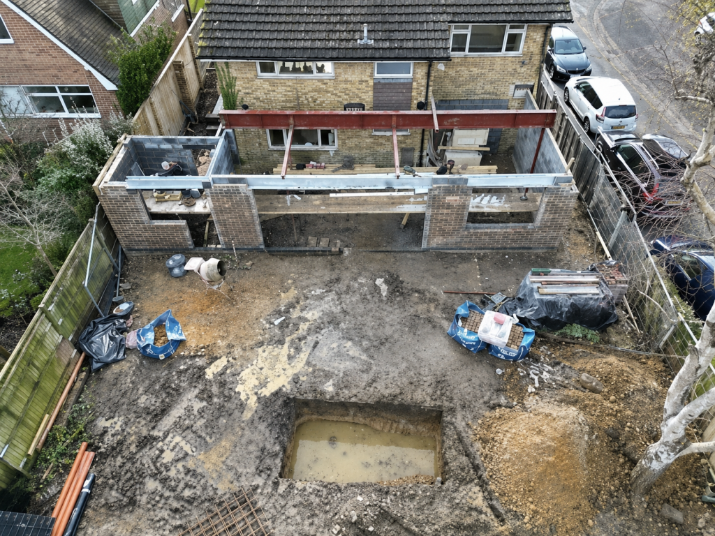 Aerial view of excavated foundations and blockwork for a rear house extension