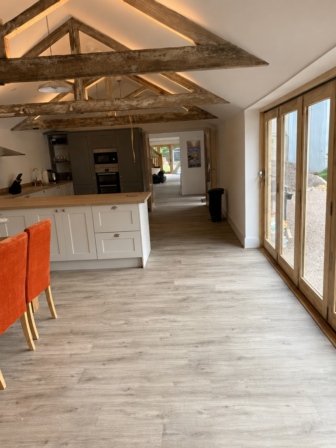 Black fitted kitchen with white worktops and a timber floor