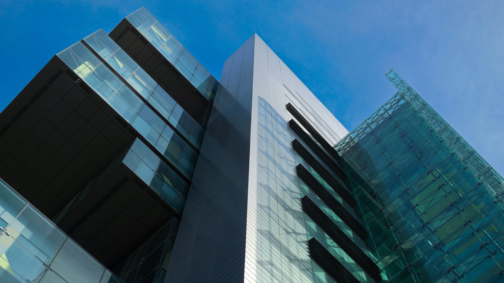 a tall glass building with a sky background