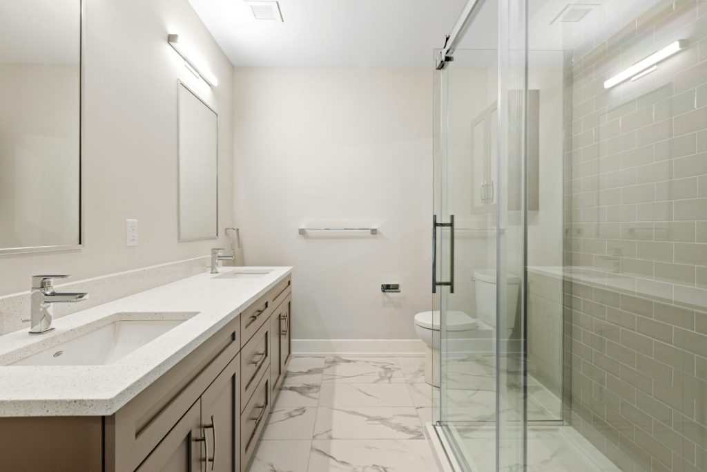 Bright modern bathroom with a long vanity, walk-in shower and toilet